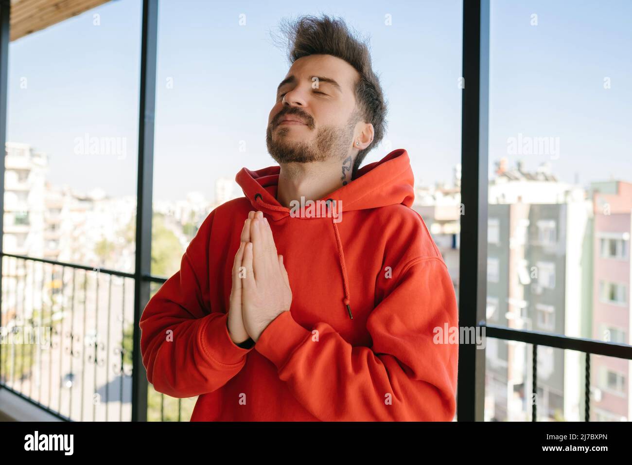 Croyant, le jeune homme a classé les mains priant et envoyant l'énergie positive, la méditation et la croyance religieuse Banque D'Images