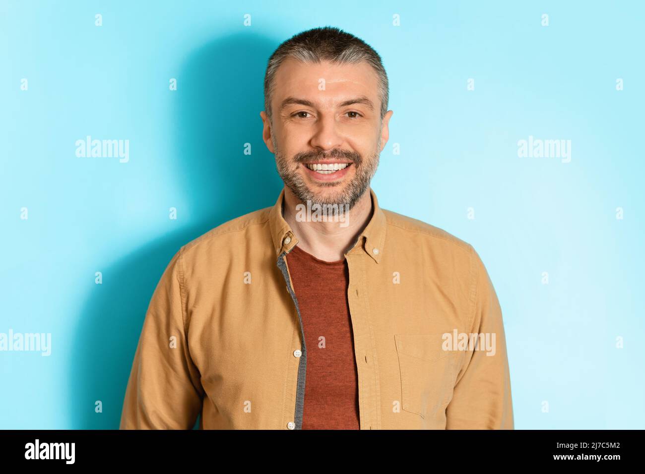 Portrait d'un homme heureux d'âge moyen sur fond bleu Banque D'Images