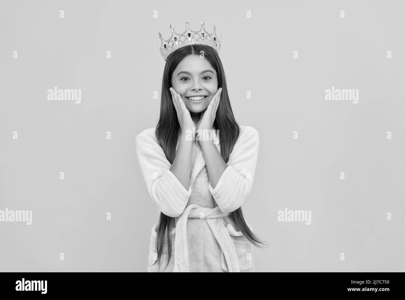 smug bonne jeune fille dans la maison terry peignoir et princesse couronne, la contrebande Banque D'Images