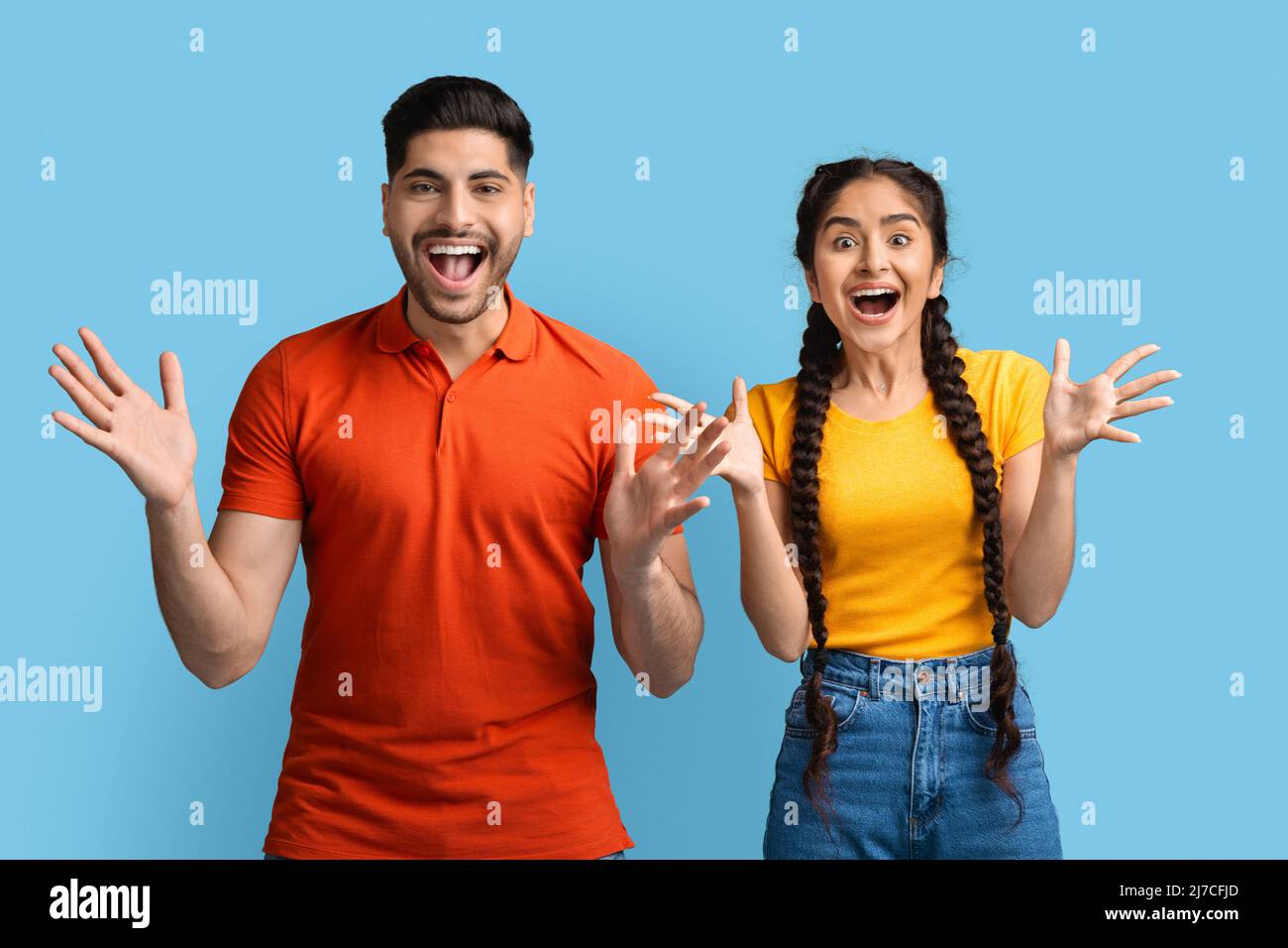 Émotions humaines. Portrait d'un jeune couple arabe surpris qui se répand les mains avec enthousiasme Banque D'Images