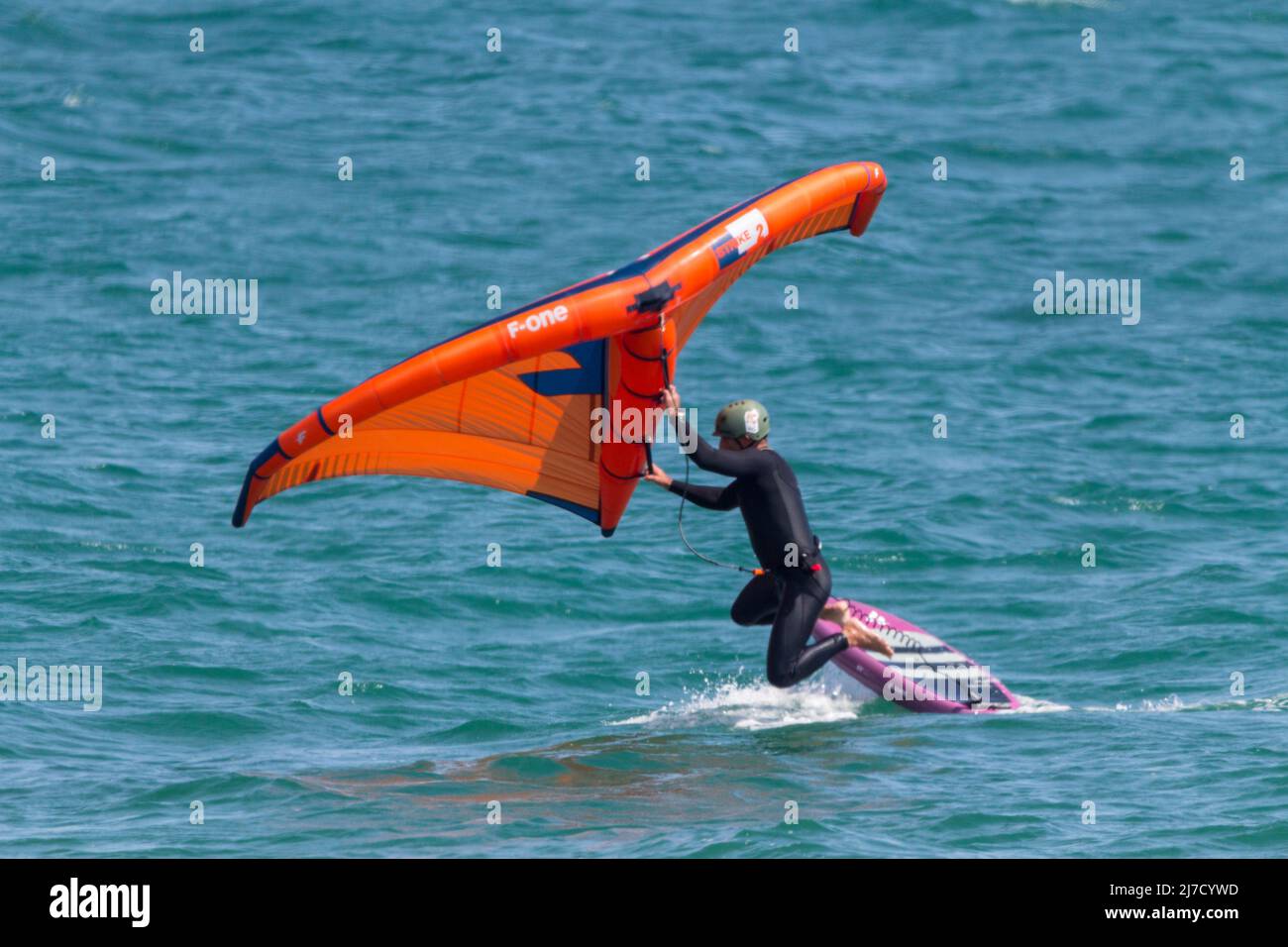 Planche à voile surf à l'aide d'une planche à voile avec des lames  hydroglissées sous-marines qui s'élèvent à la surface en mouvement, et une  voile gonflable à main Photo Stock - Alamy