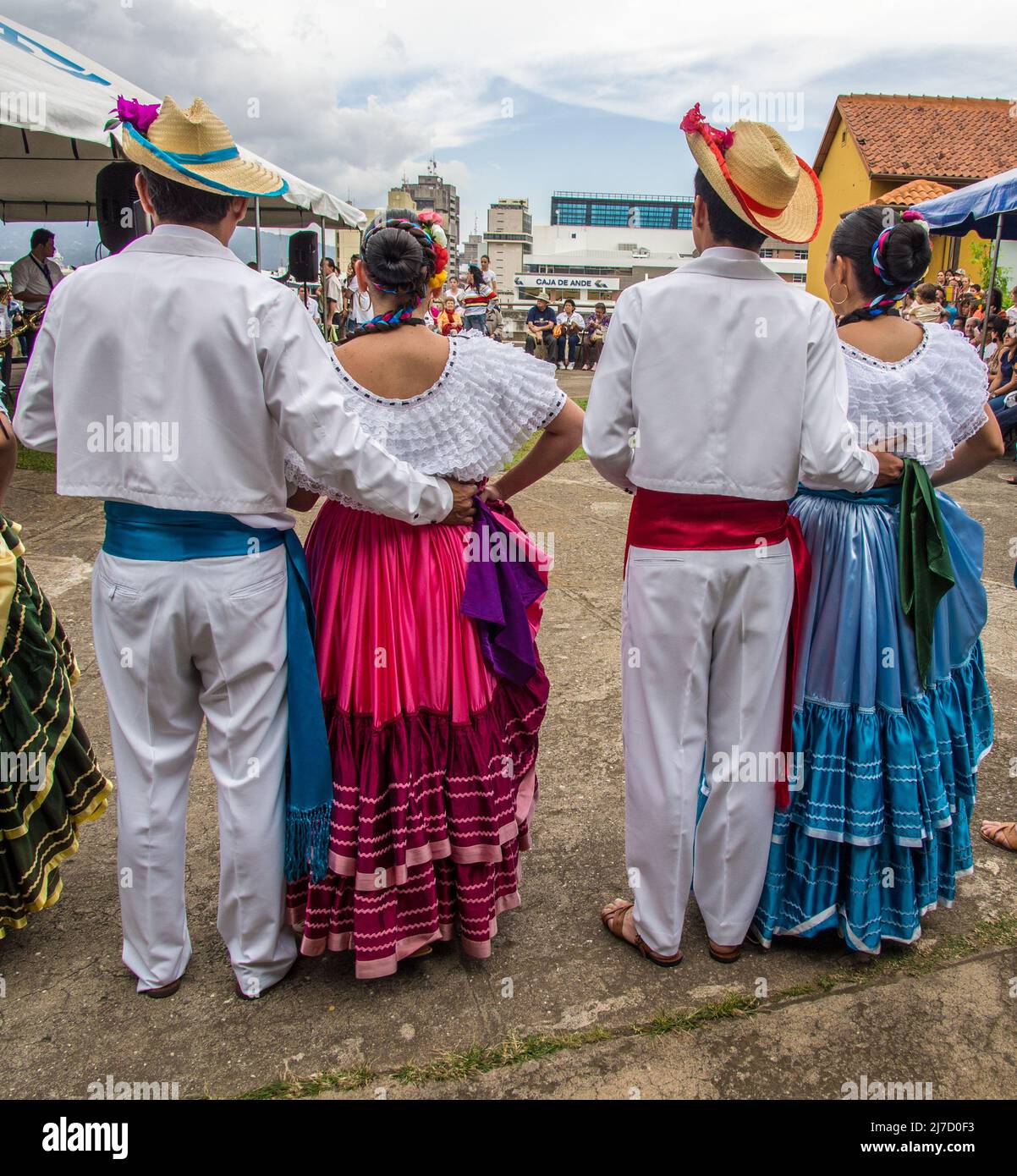 Vue arrière de quatre danseurs folkloriques en vêtements traditionnels attendant leur tour pour se produire à San José, Costa Rica. Banque D'Images