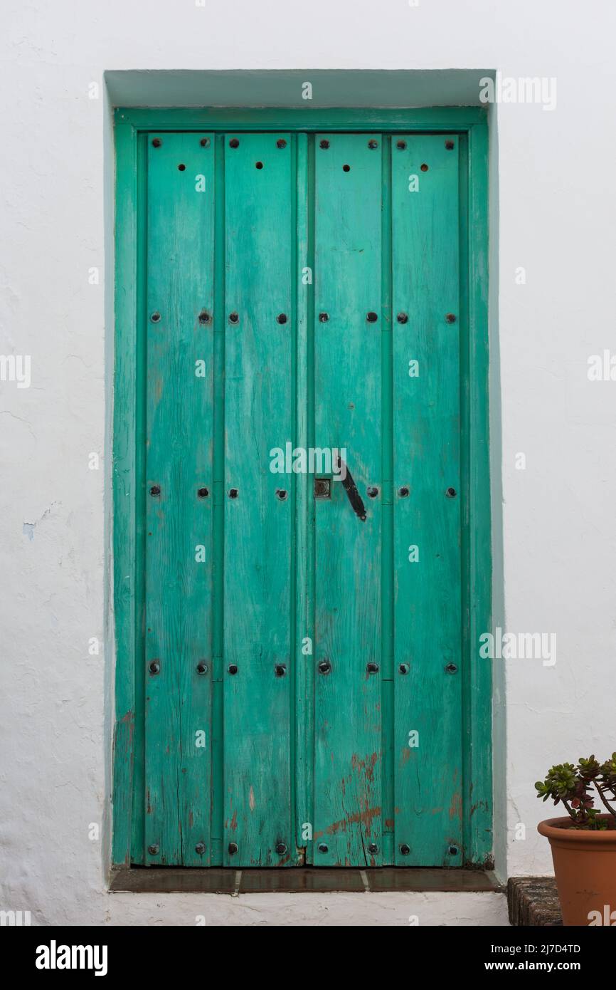 Porte verte vintage avec clous noirs et bouton en Frigiliana. Malaga, Andalousie, Espagne Banque D'Images