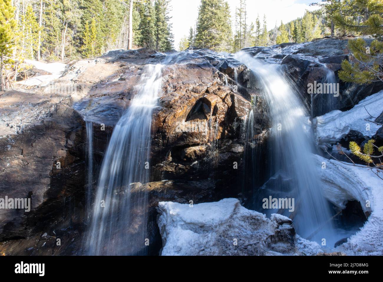 En hiver, une chute d'eau se répand en cascade sur une montagne dans la neige Banque D'Images