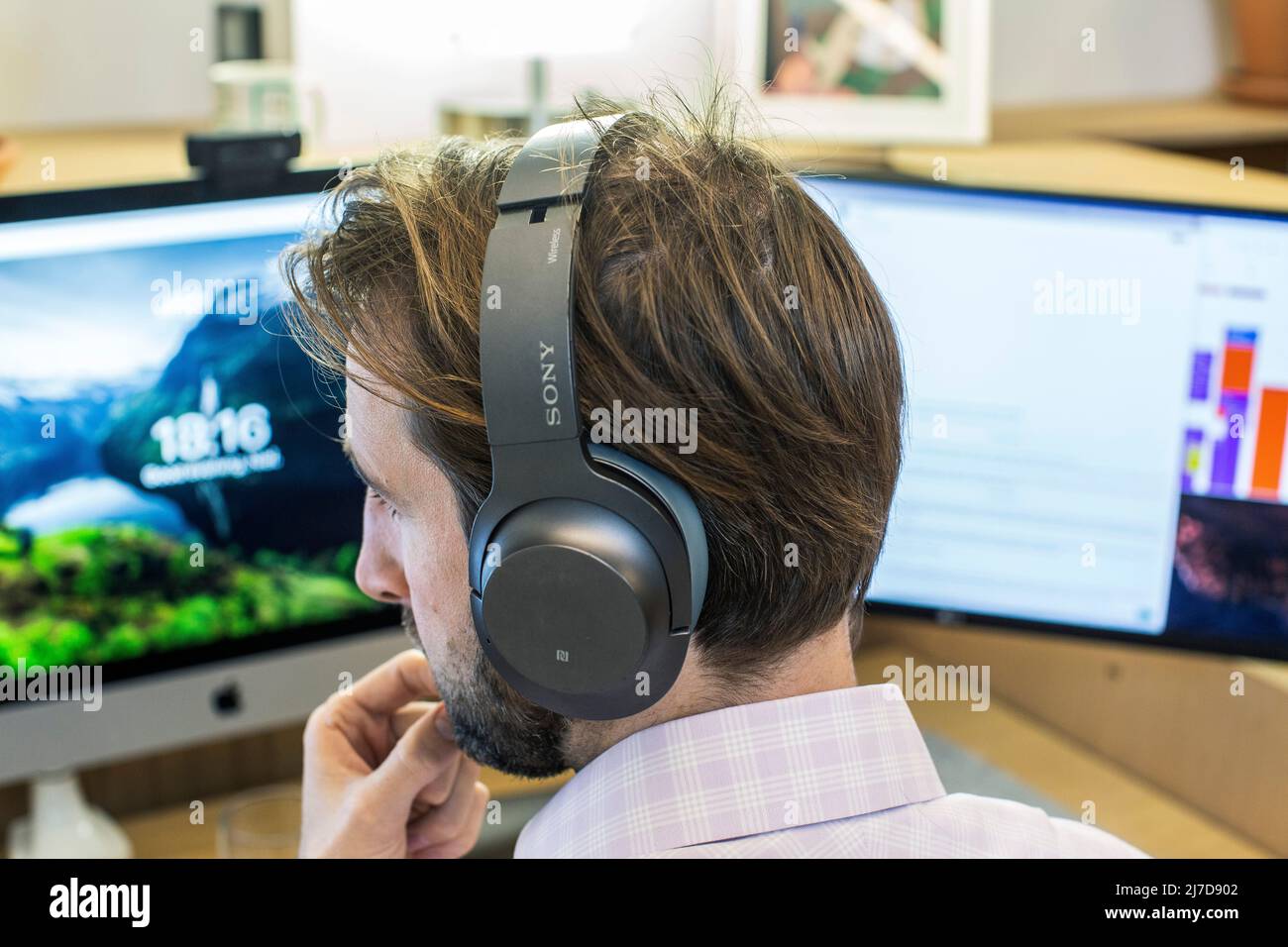 Homme attentif avec casque utilisant un ordinateur dans un bureau Banque D'Images