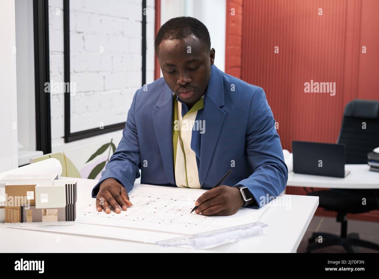 Un homme de designer africain se concentrant sur son travail à table, il dessine le plan de plan d'appartement Banque D'Images