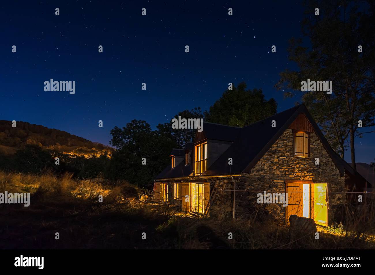 Authentique grange pyrénéenne rénovée dans la vallée de l'Aure. Construction en pierre et bois exposés. Photo de nuit Banque D'Images