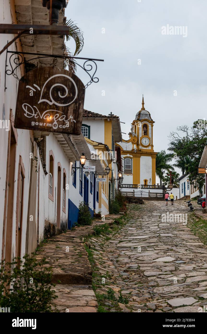 La Rua da Camara en montée rue pavée avec une rangée de maisons coloniales côte à côte avec vue partielle de l'église mère de Santo Antonio à l'arrière. Banque D'Images