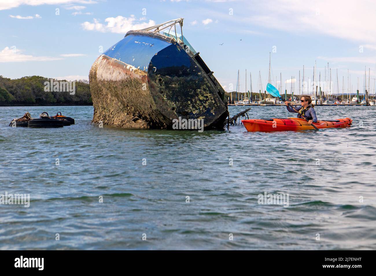 Faire du kayak en passant devant un yacht épaté dans la rivière Port Banque D'Images