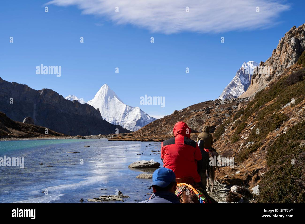 vue arrière des touristes asiatiques à cheval voyageant dans le parc national de yading dans le comté de daocheng, chine Banque D'Images