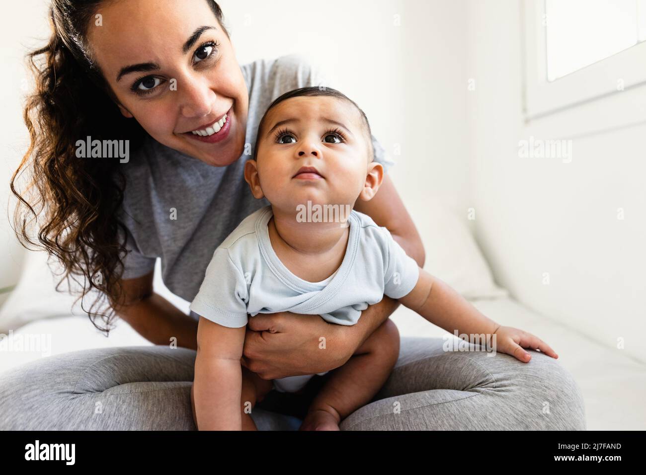 Bonne mère s'amuser avec son petit bébé au lit - concept de famille et de maternité Banque D'Images