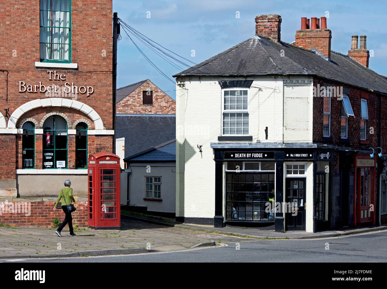 Femme marchant sur High Street, Epworth, North Lincolnshire, Angleterre Royaume-Uni Banque D'Images