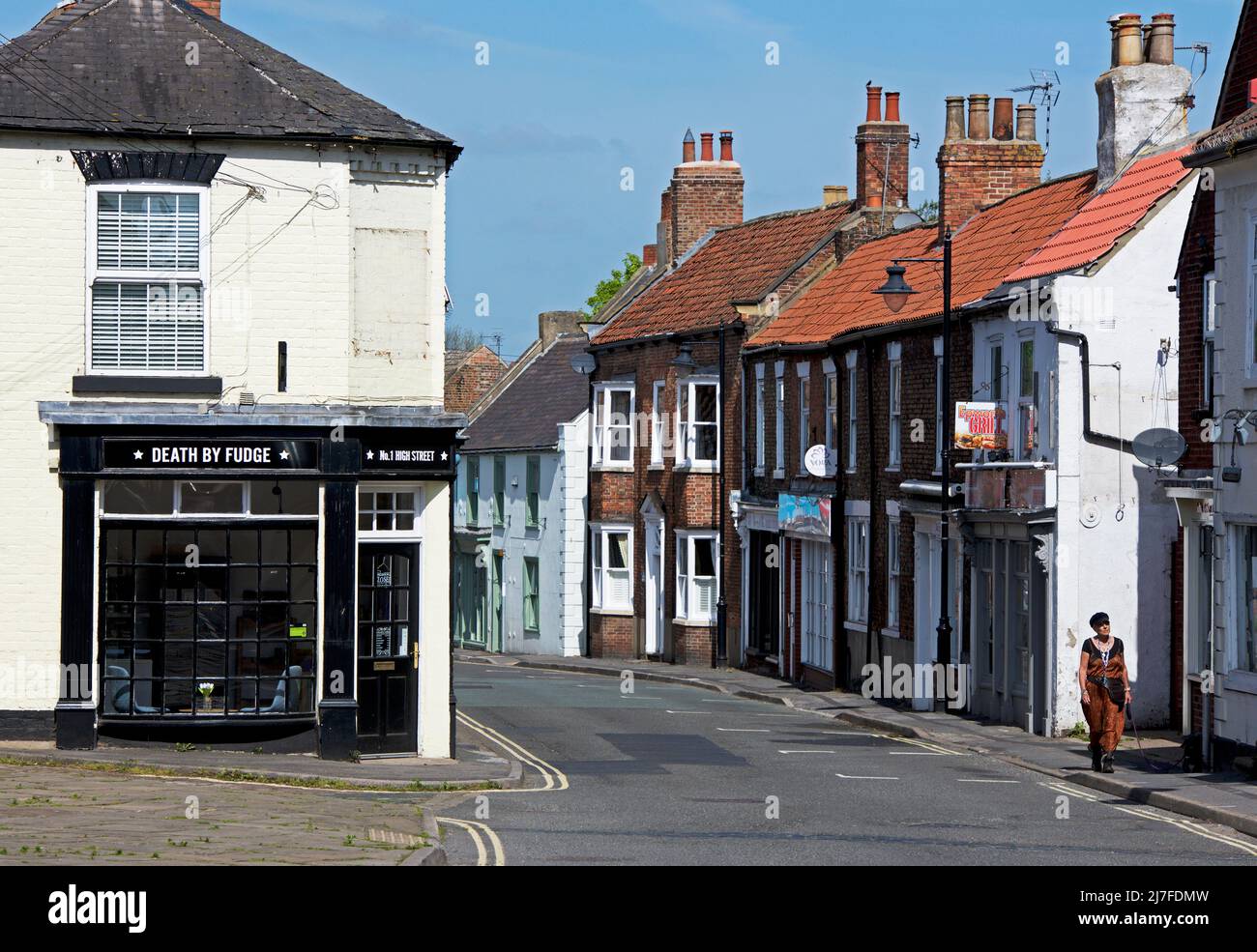 Femme marchant sur High Street, Epworth, North Lincolnshire, Angleterre Royaume-Uni Banque D'Images