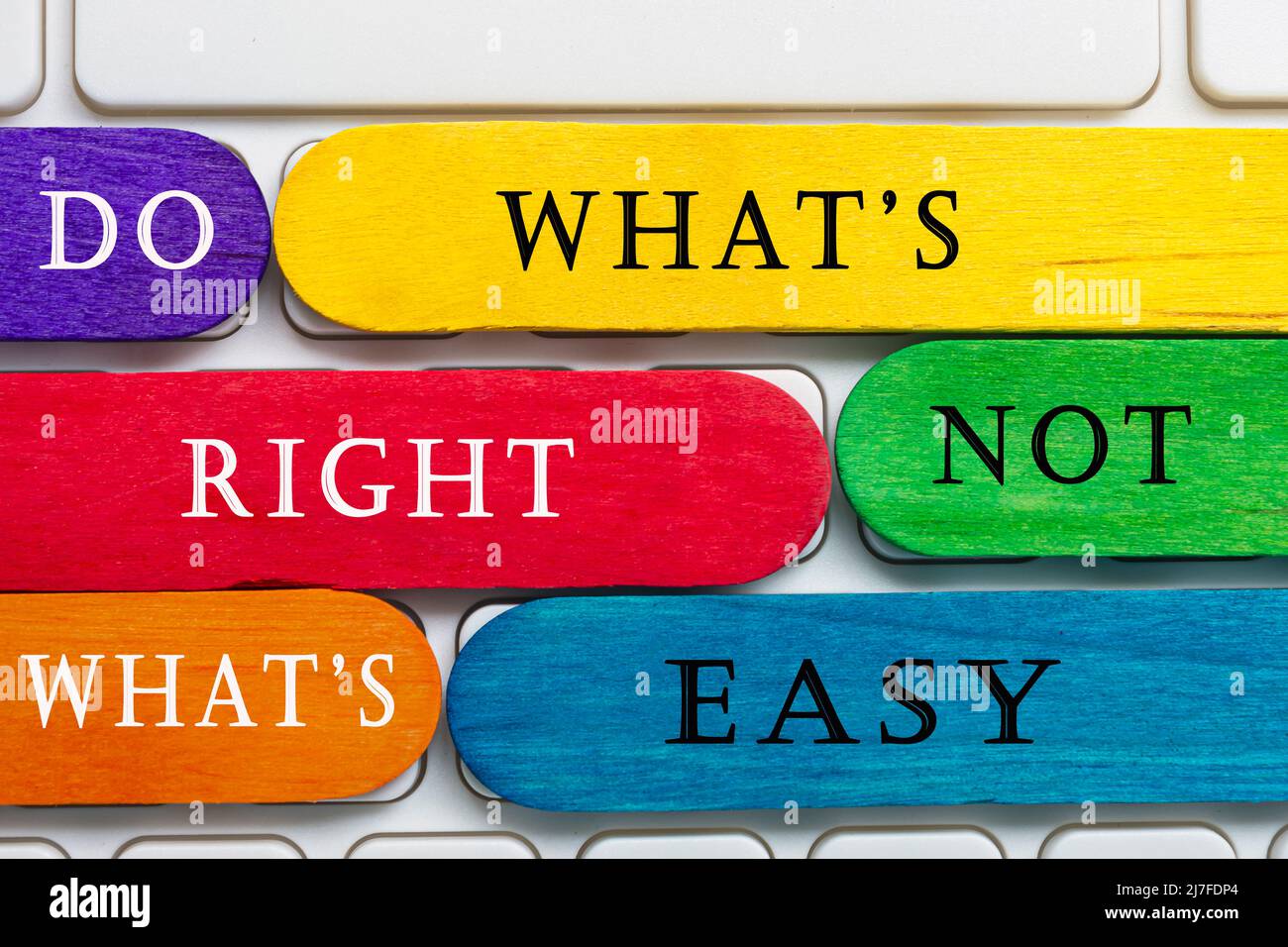 Bâtons en bois coloré avec mot sur un clavier blanc - faire ce qui est droit pas ce qui est facile. Banque D'Images