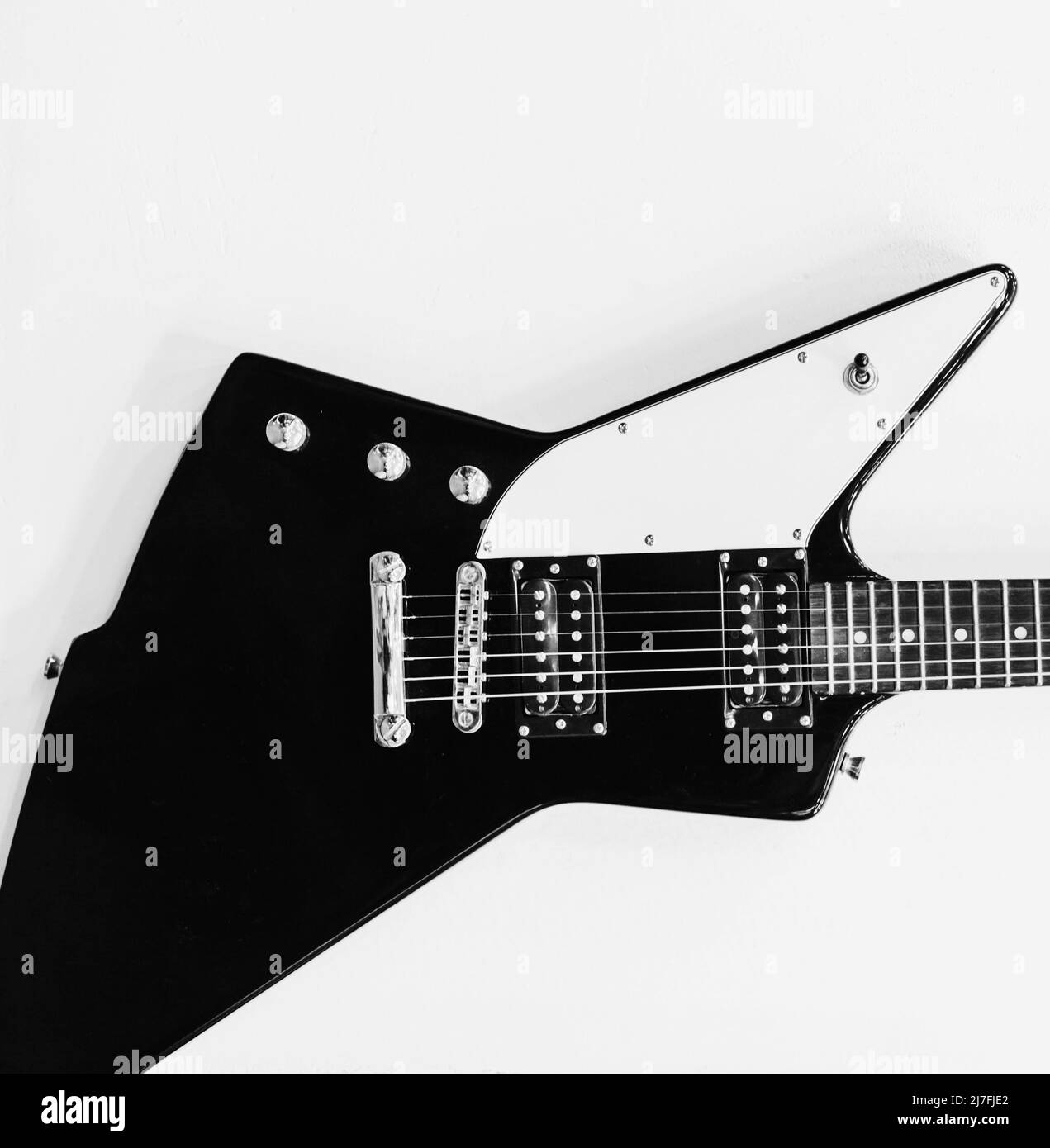 Guitare noire et blanche accrochée au mur. Copier l'espace Banque D'Images