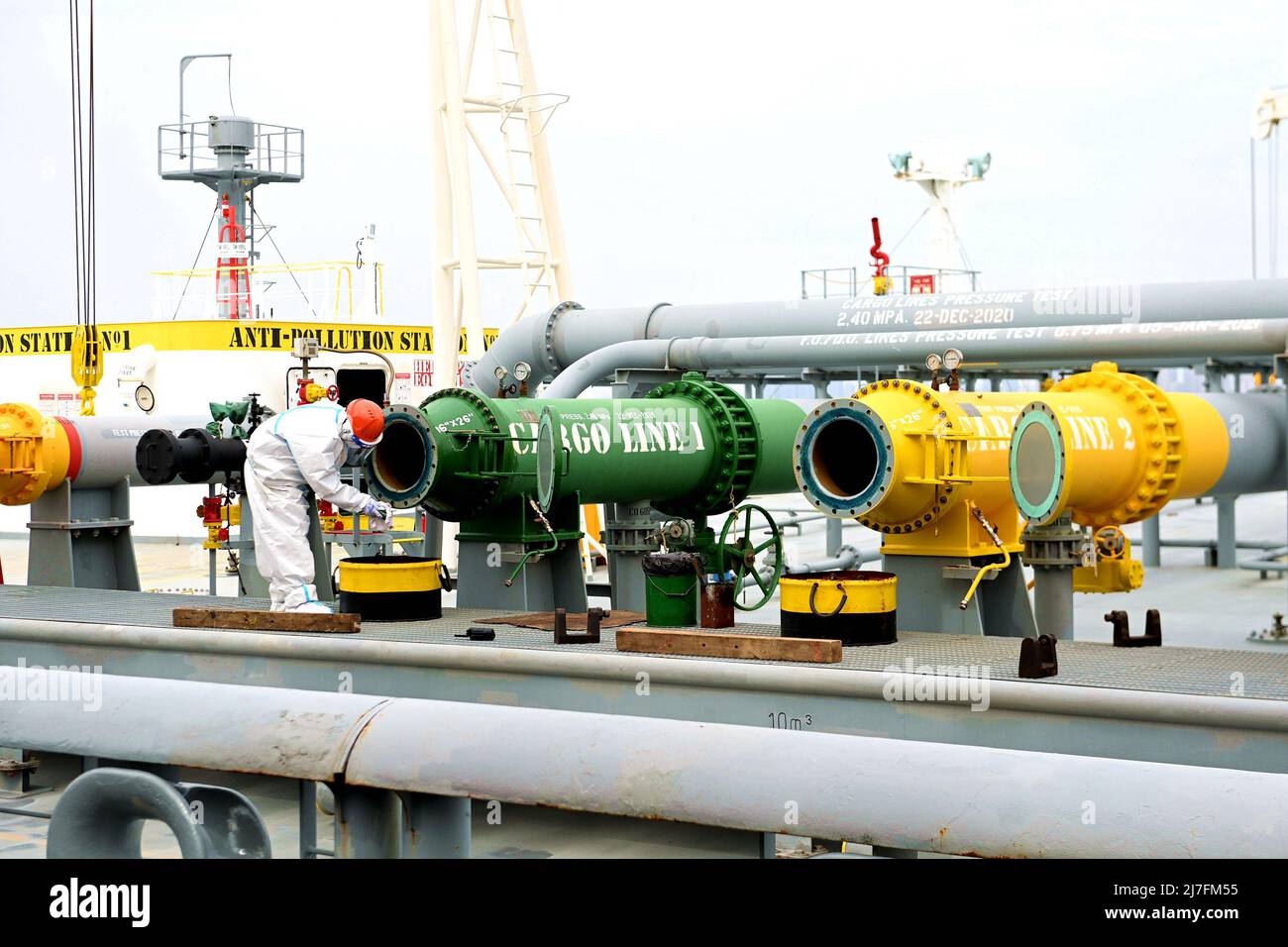 QINGDAO, CHINE - le 9 MAI 2022 - Un travailleur à quai nettoie l'arrivée d'huile d'un pétrolier à Qingdao, dans la province de Shandong, en Chine orientale, le 9 mai 2022. Selon cus Banque D'Images