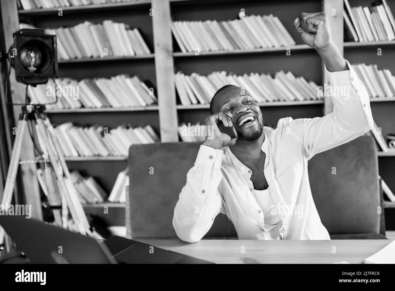 Joyeux Manager afro-américain porter des écouteurs fournir un soutien au client de loin, tenir une conférence en ligne. Etudiant de loin au bleu moderne Banque D'Images