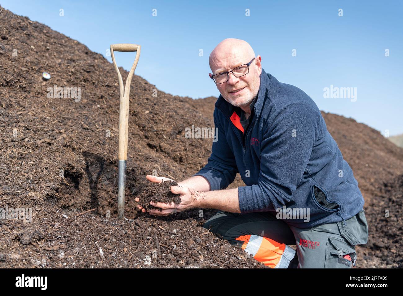 Un agriculteur inspecte une pile de fumier de cour de ferme qui a été compostée, pour aider à prévenir le lessivage de l'azote du sol. North Yorkshire, Royaume-Uni. Banque D'Images