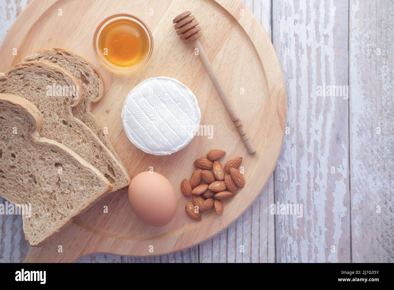 fromages frais, miel, œuf et pain sur une assiette Banque D'Images