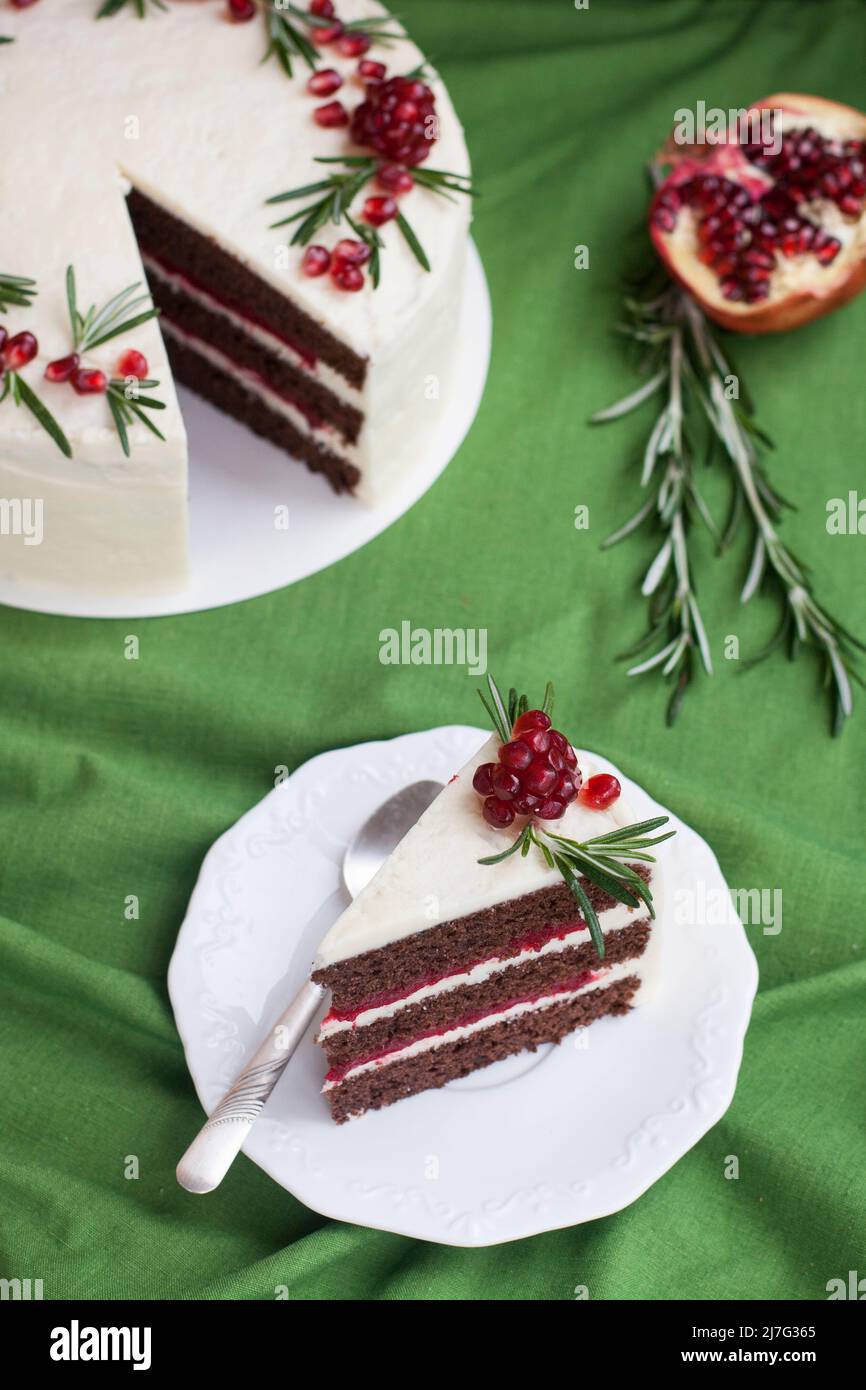 Gâteau au chocolat avec crème de baies, crème au fromage blanc, baies de grenade et branches de romarin. Idée pour un gâteau d'anniversaire ou pour un gâteau de mariage. Banque D'Images