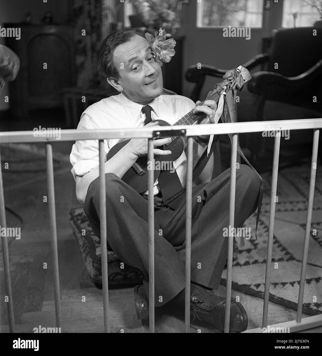 Père en 1940s. L'acteur Åke Söderblom, 1910-1965 ans, fait de son mieux pour amuser son fils de l'extérieur du parc à jouer de la guitare. Suède 1949 AN92-2 Banque D'Images