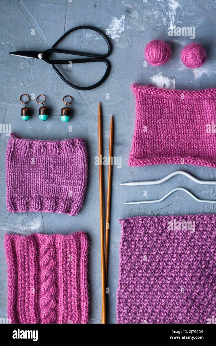 Vue de dessus: Les accessoires de tricotage et les échantillons de produits tricotés se trouvent sur un fond en béton gris. Lieu d'inscription. Banque D'Images