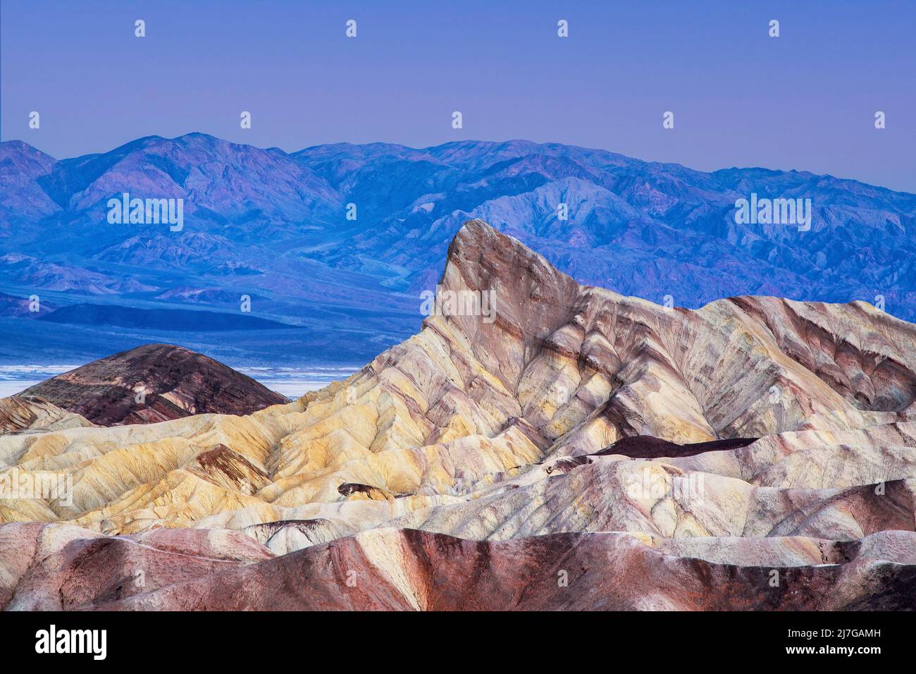 Aube à Zabriskie point, parc national de la Vallée de la mort, Californie. Les formations colorées de Manly Beacon avec les Badlands et les montagnes dans la dista Banque D'Images