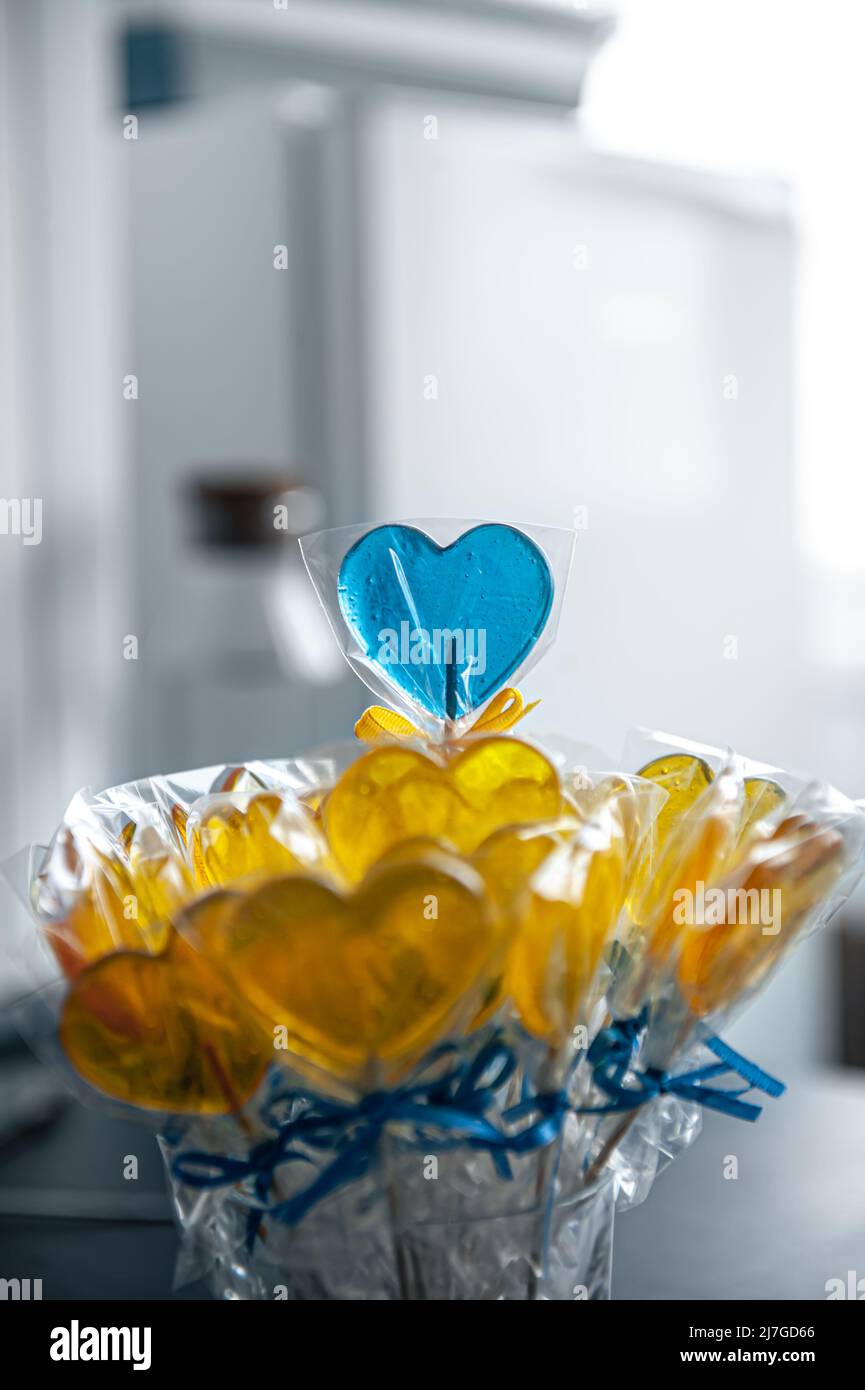 Sucettes en forme de coeur jaune et bleu au caramel. Banque D'Images