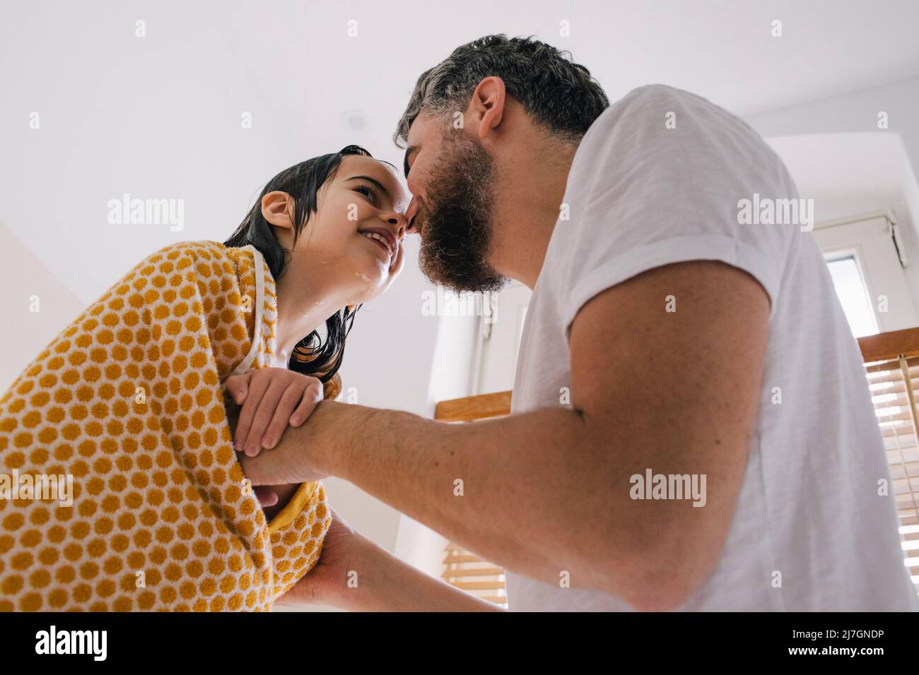 Un père souriant et une fille se frottant le nez dans la salle de bains à la maison Banque D'Images