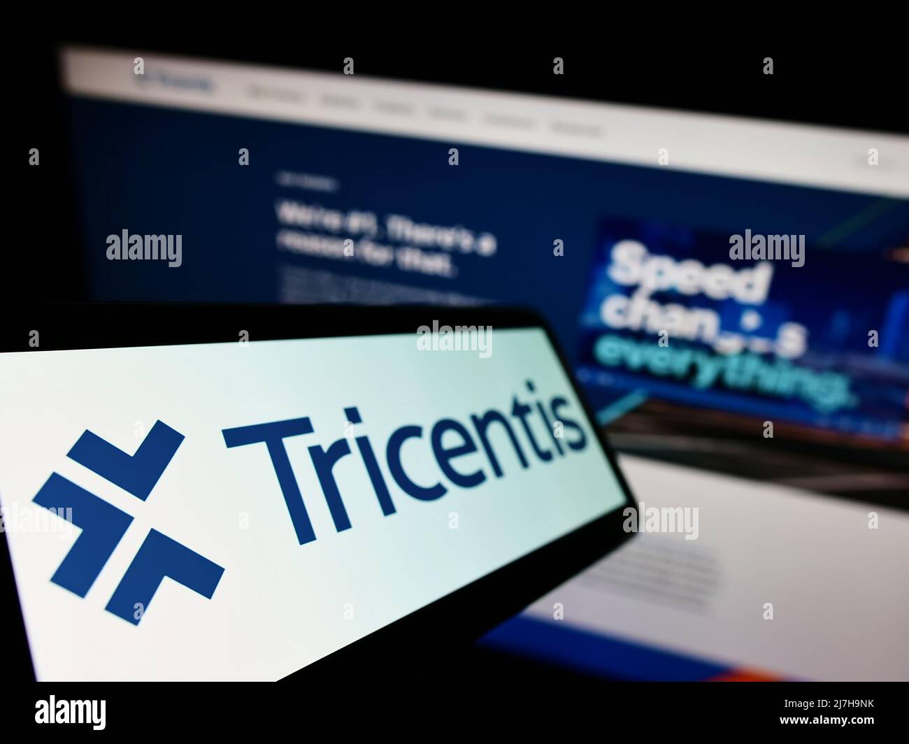 Téléphone portable avec logo de la société autrichienne de logiciels, Tricentis GmbH, sur écran devant le site Web des entreprises. Mise au point à gauche de l'écran du téléphone. Banque D'Images