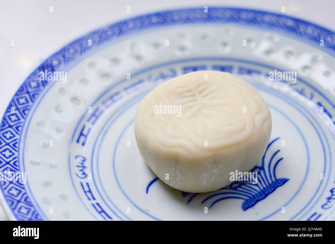 Chine, août 2018. Un gâteau blanc chinois de lune neigeux fait par 'Meixin' (marque) isolé sur une assiette. Banque D'Images