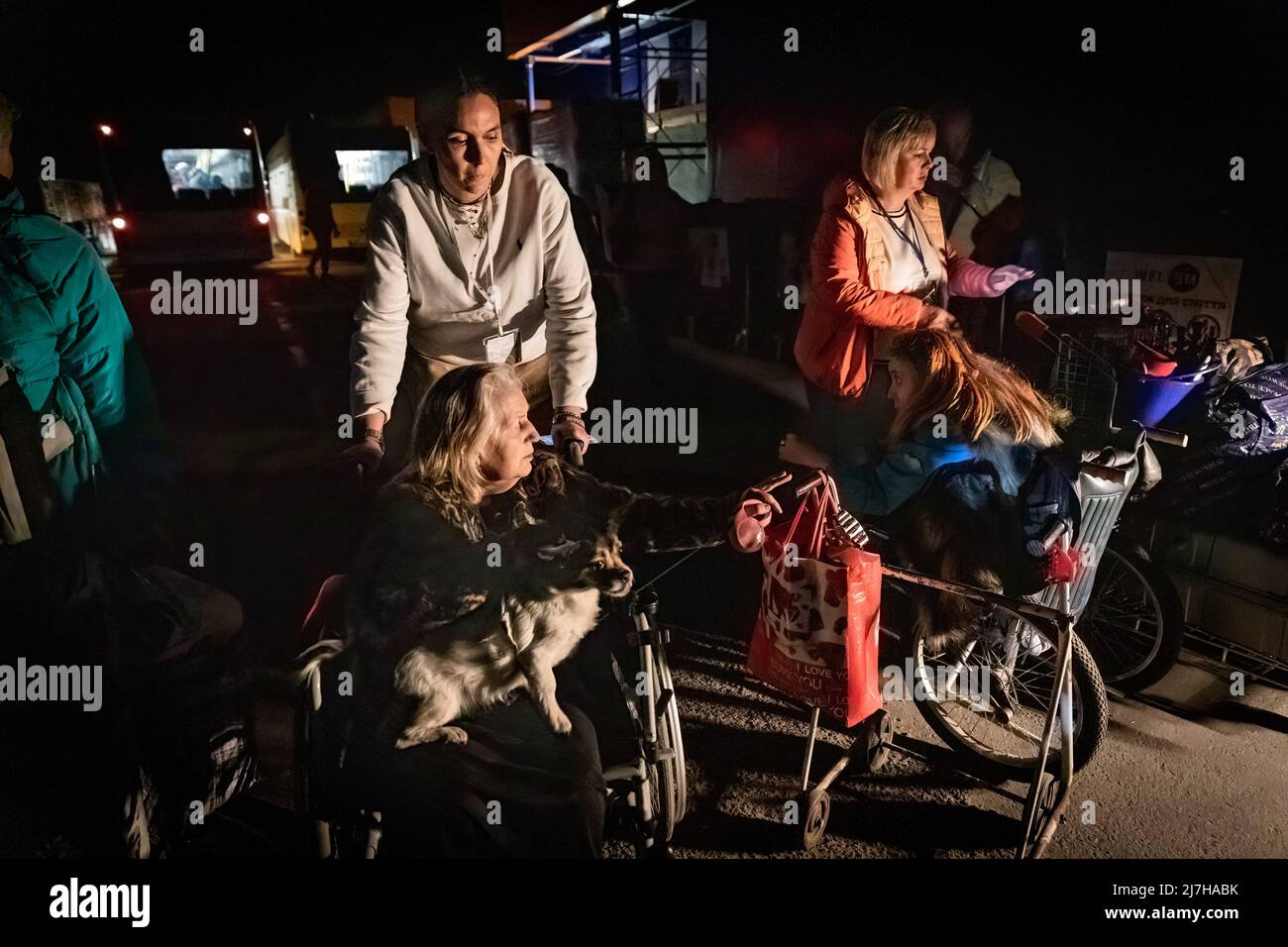 Les volontaires poussent les fauteuils roulants de Valetyina et Elena et leur chien après leur arrivée de Marioupol à Zaporizhia le dimanche soir. Les Nations Unies et la Croix-Rouge ont maintenant évacué plus de 300 000 civils de Marioupol, contrôlé par la Russie, alors que la dernière vague d'évacuations d'Azovstal atteint la sécurité dans Zaporizhia, contrôlé par l'Ukraine, dimanche soir. Le président ukrainien Zelenskiy a déclaré samedi que la première phase d'évacuation du dernier bastion de Mariupolës, Azovstal, était achevée. Selon les Nations Unies, plus de 11 millions de personnes auraient fui leurs foyers en Ukraine depuis le conformphe Banque D'Images