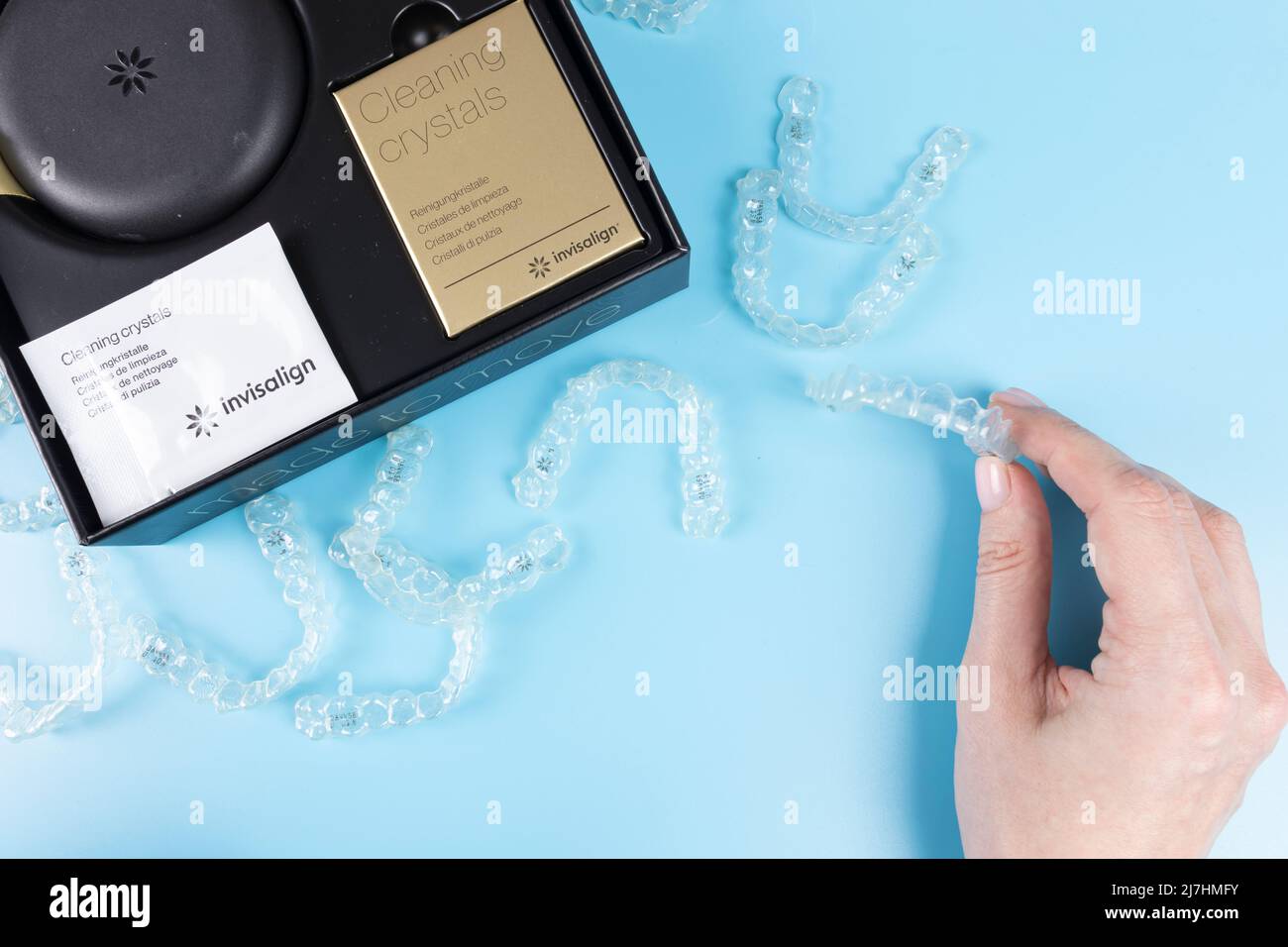 Barcelone, Espagne, 01 mai 2022: Femme tenant des retenues transparentes invisalign avec une boîte sur la table, vue de dessus platlay Banque D'Images