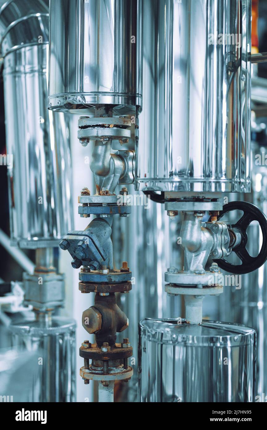 Grand tube avec petite vanne noire à l'usine de production Banque D'Images