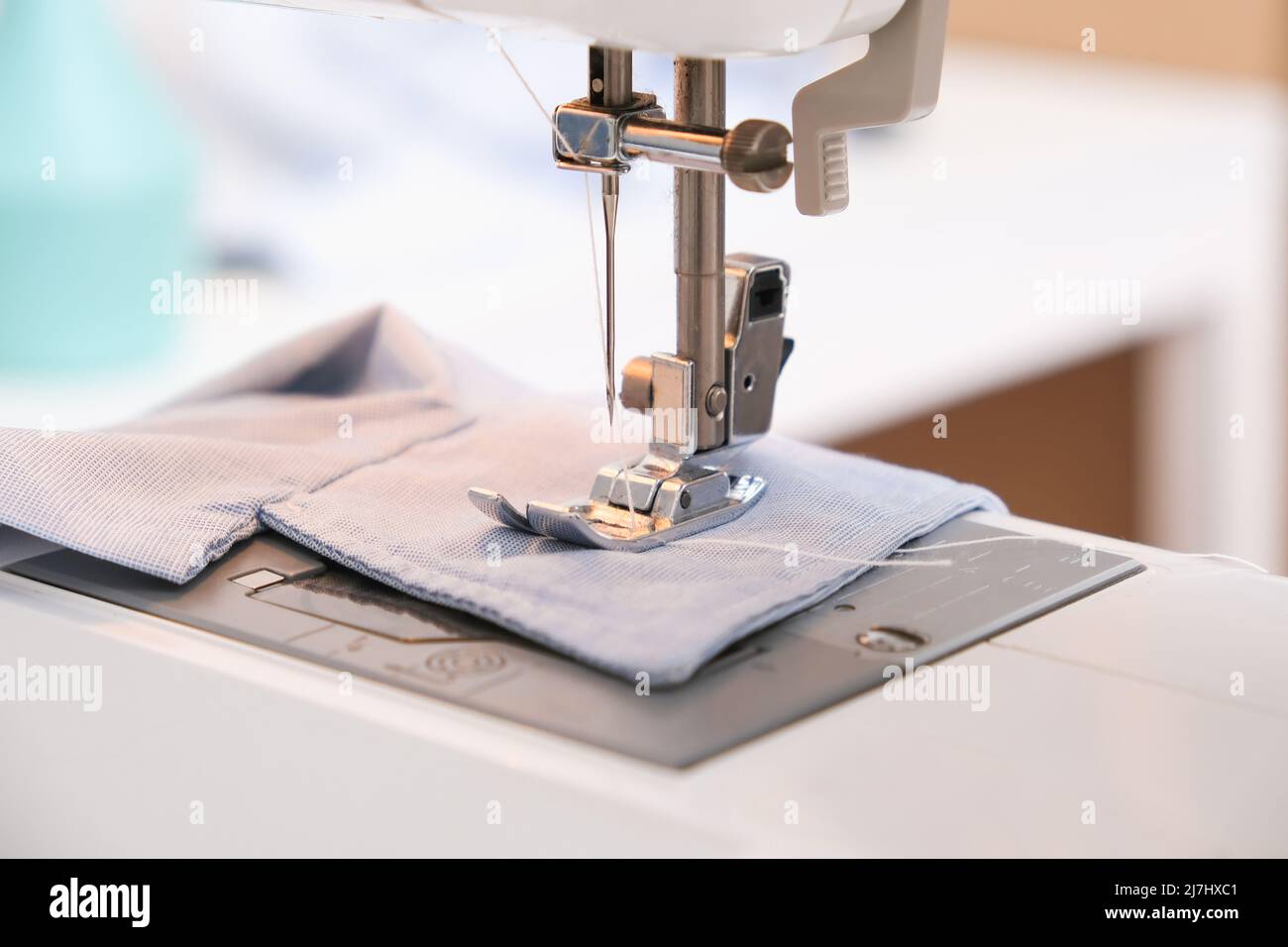 Un homme rade des vêtements sur une machine à coudre. Passe-temps, travail du besoin, créativité. Banque D'Images