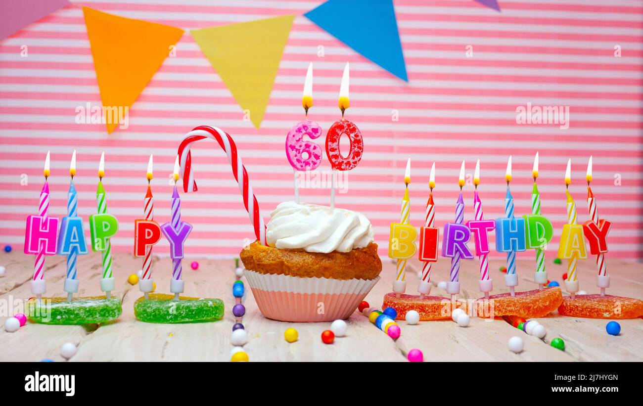 Carte d'anniversaire sur fond rose, avec une figurine dans un cupcake. Magnifique fond joyeux anniversaire avec un nombre avec une bougie en feu. Festif Banque D'Images