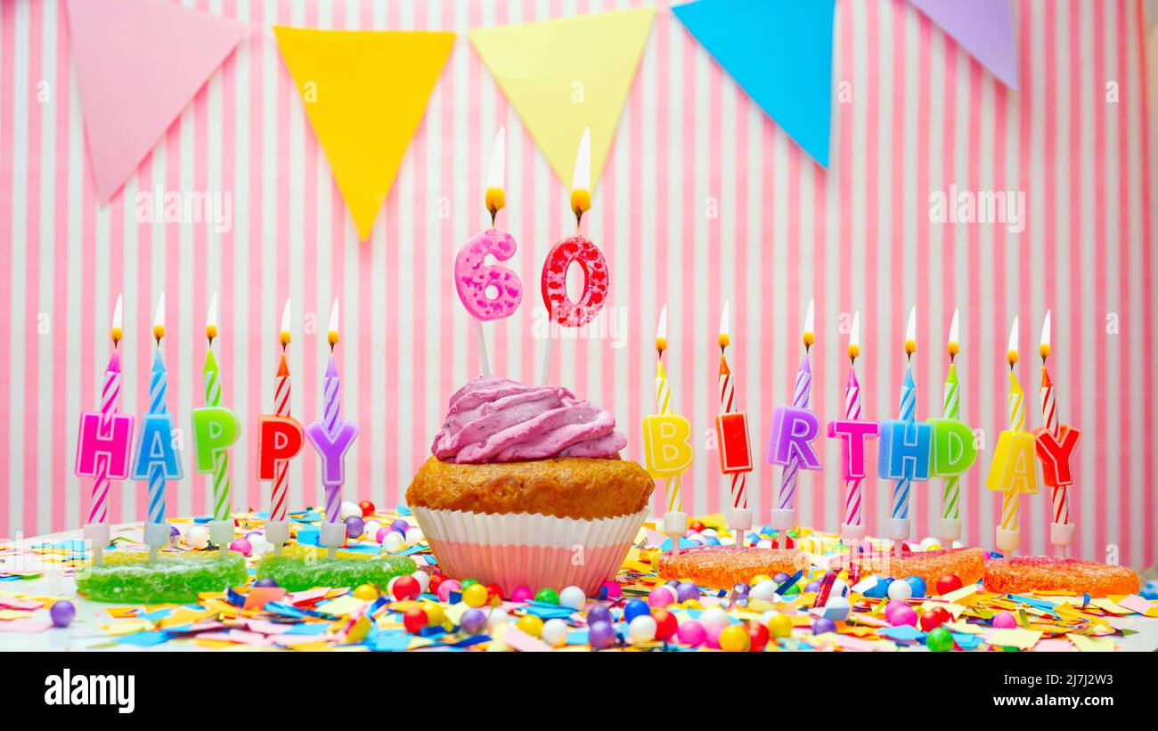 Joyeux anniversaire. Sur fond rose, un joyeux anniversaire pour un enfant. Cupcakes à la crème rose avec une bougie allumée. Copier l'espace. Banque D'Images