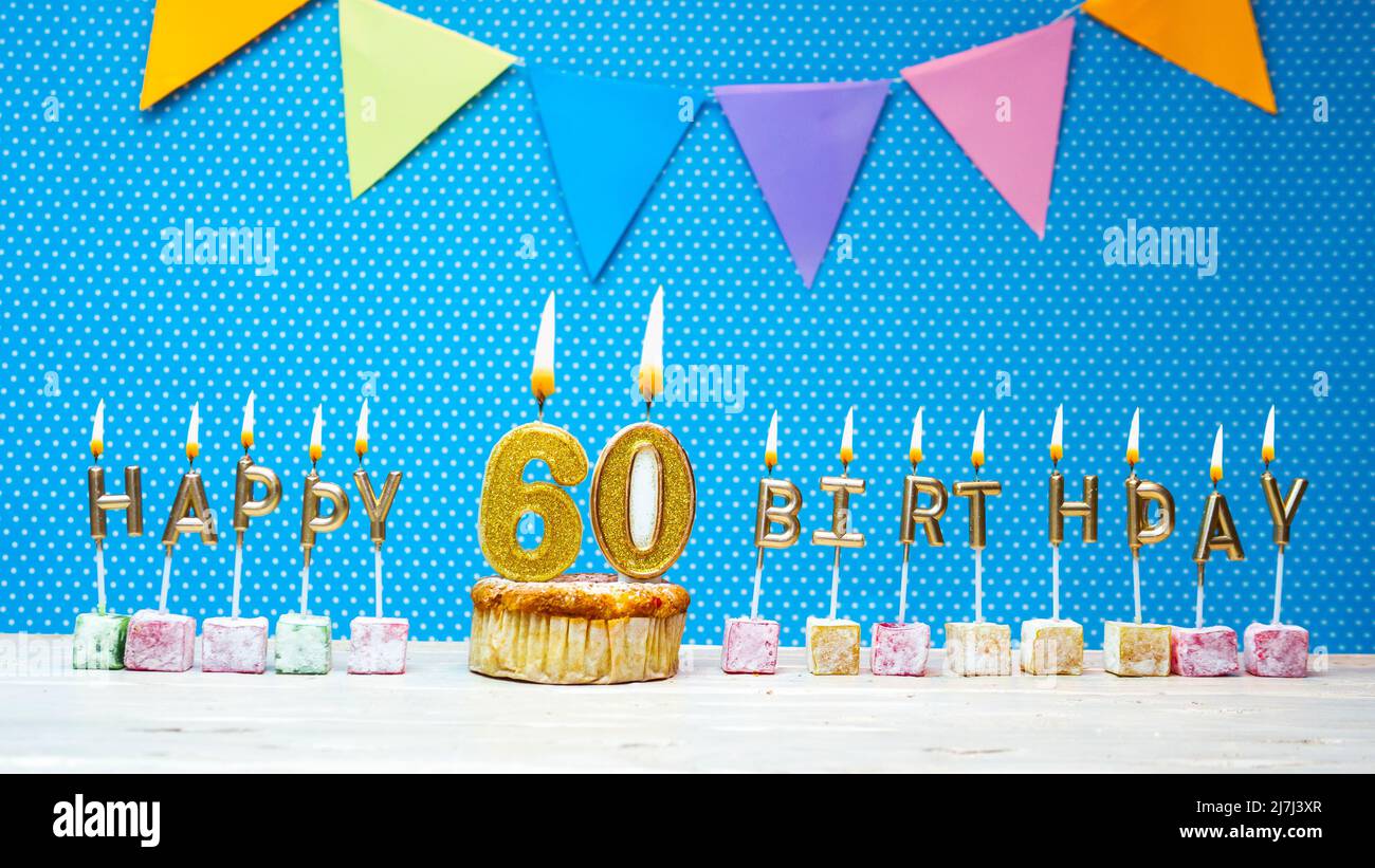 Joyeux anniversaire à partir de lettres aux chandelles sur un fond bleu avec un espace de copie à pois blanc. Gâteau d'anniversaire joyeux avec bougie dorée Banque D'Images