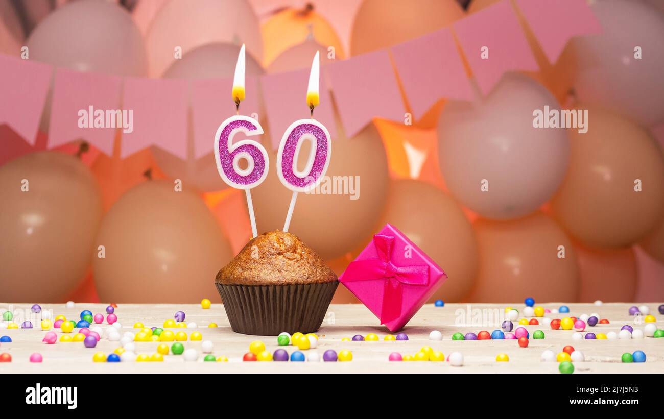 Ballons décorations et une bougie d'anniversaire heureuse avec un nombre dans un gâteau. Joyeux anniversaire voeux en couleurs roses pour une fille, espace copie. Muffin Banque D'Images