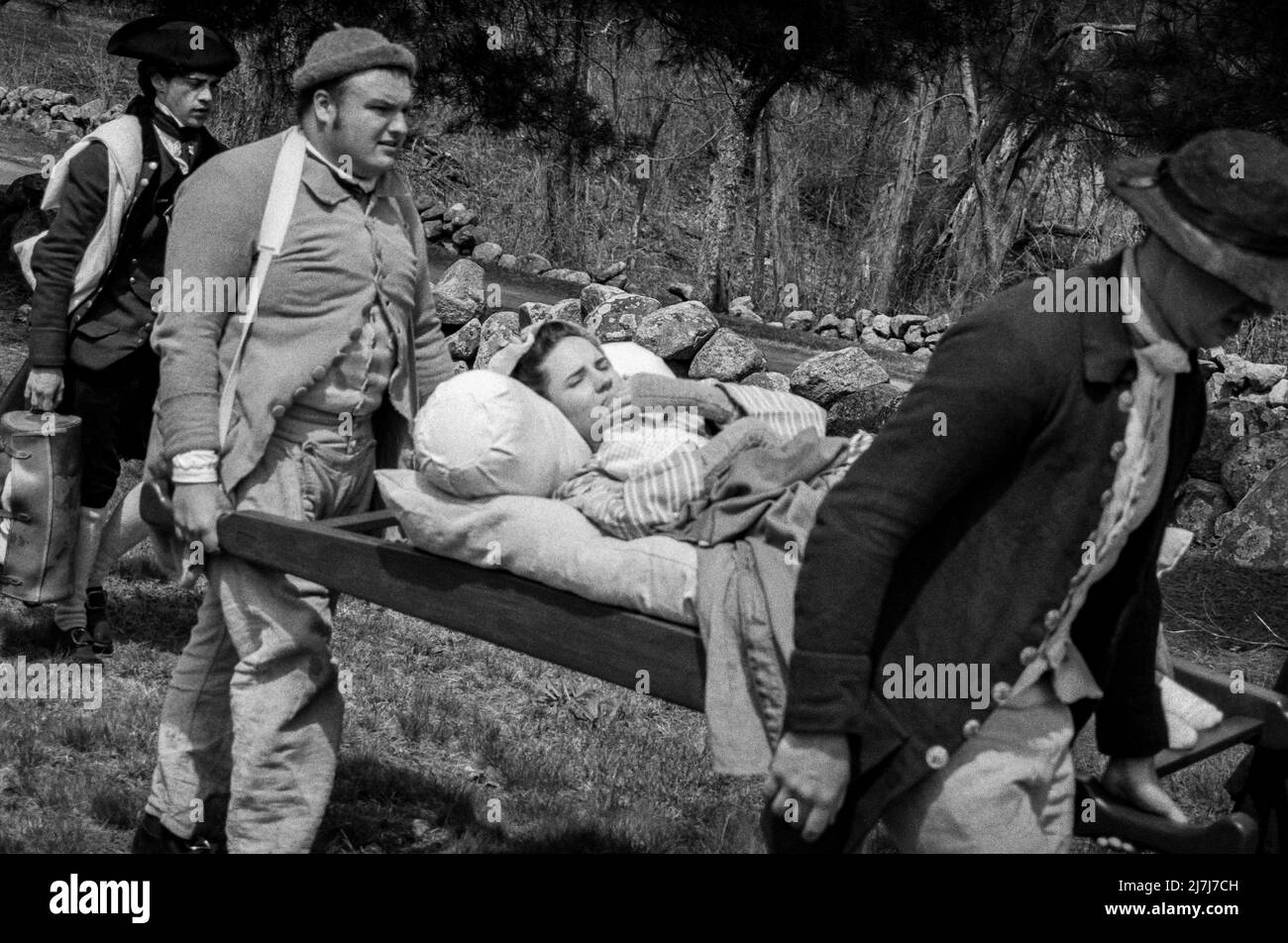 Reconstitution des acteurs transportant un soldat blessé pendant la simulation d'attaque des Redcoats sur Battle Road à Lexington le week-end des Patriots. Lexing Banque D'Images