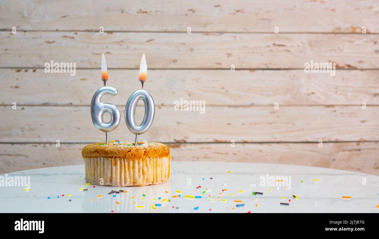 Joyeux anniversaire chiffres argentés sur les tableaux blancs arrière-plan de l'espace de copie. Belle carte d'anniversaire avec un cupcake et une bougie Banque D'Images