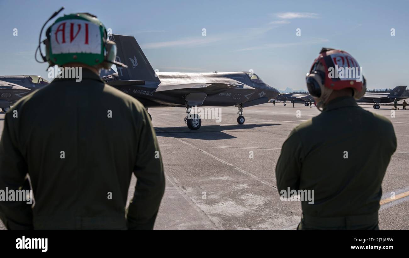 Caporal de lance du corps des Marines des États-Unis Alan Curtis, technicien en avionique de l'escadron d'attaque de chasseurs maritimes 242, à gauche, et Cpl. Leon Nguyen, un technicien en munitions, à droite, observe un F-35B Lightning II commencer à prendre un taxi sur la piste pour les opérations de vol pour soutenir l'exercice RED FLAG-Alaska 22-1 à la base aérienne d'Eielson, Alaska, le 30 avril 2022. RF-A est une plate-forme idéale pour l'engagement international, permettant l'échange de tactiques, techniques et procédures tout en améliorant l'interopérabilité afin de maintenir une Indo-Pacific libre et ouverte. (É.-U. Photo du corps marin par Cpl. Bryant Rodriguez) Banque D'Images