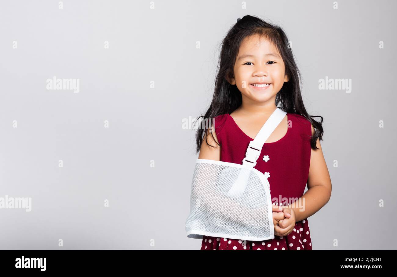 Bras cassé. Petit mignon enfant fille de 3-4 ans os de main cassé d'accident avec attelle de bras dans le studio de tir isolé sur fond blanc, enfant asiatique Banque D'Images