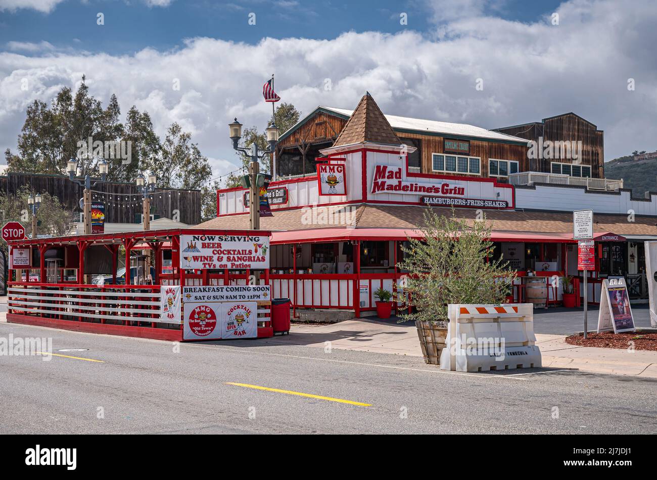 Temecula, CA, Etats-Unis - 11 avril 2022 : quartier de la vieille ville. Rouge sur le bâtiment blanc de Mad Madelines grill sous un paysage blanc. Bannières, drapeau et gre Banque D'Images