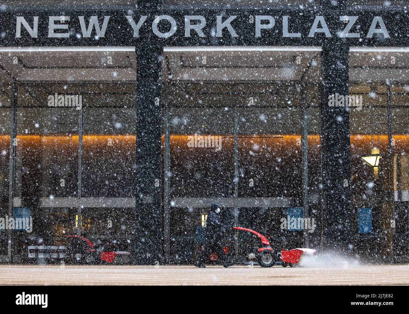 NEW YORK, New York – le 7 février 2021 : un homme d'équipage travaille devant un immeuble de bureaux à Lower Manhattan pendant une tempête d'hiver. Banque D'Images