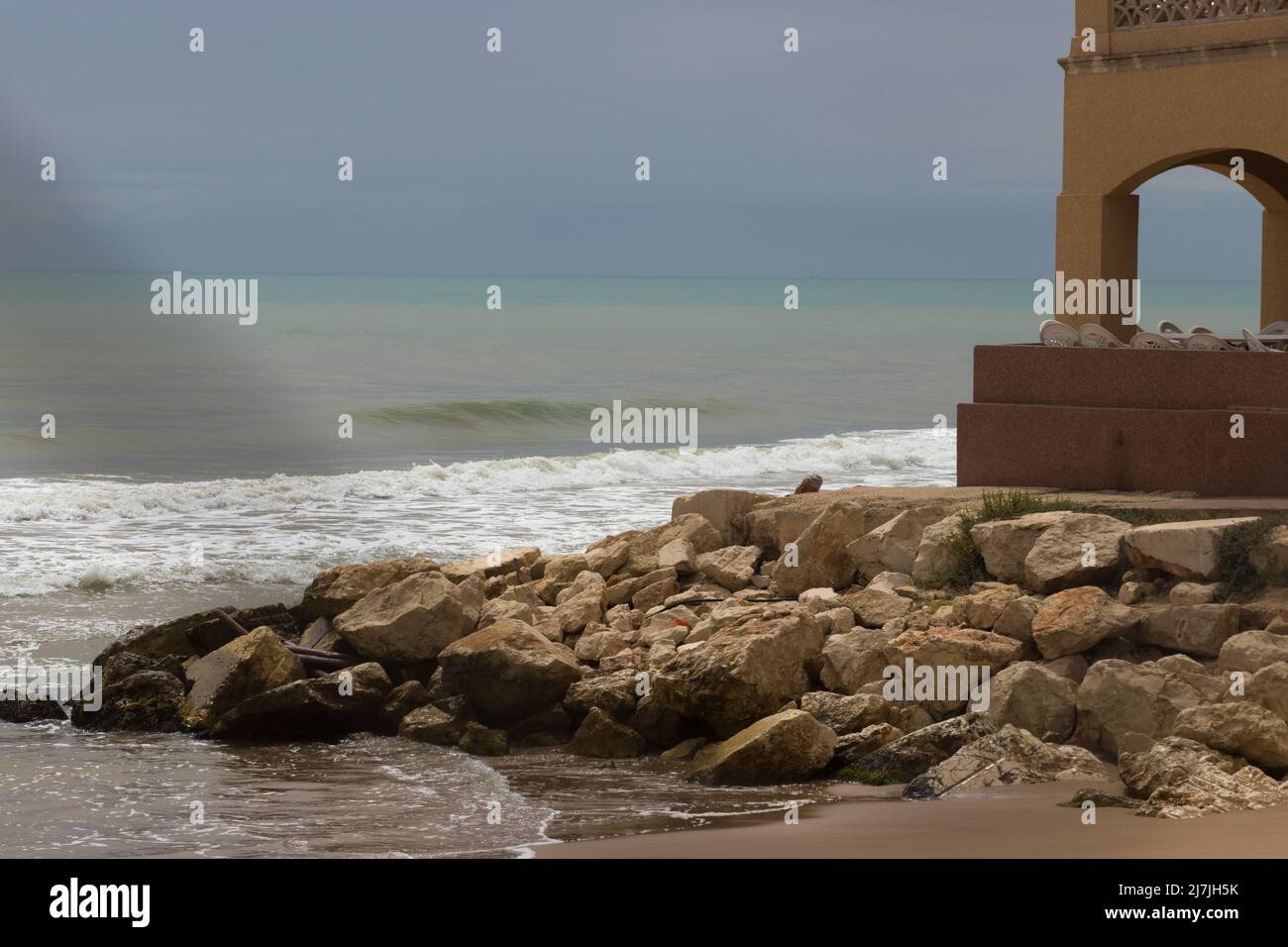 Maison de pêcheur détruite par une tempête sur les rives de la mer Méditerranée en Andalousie, Espagne. Vue à travers une clôture. Banque D'Images