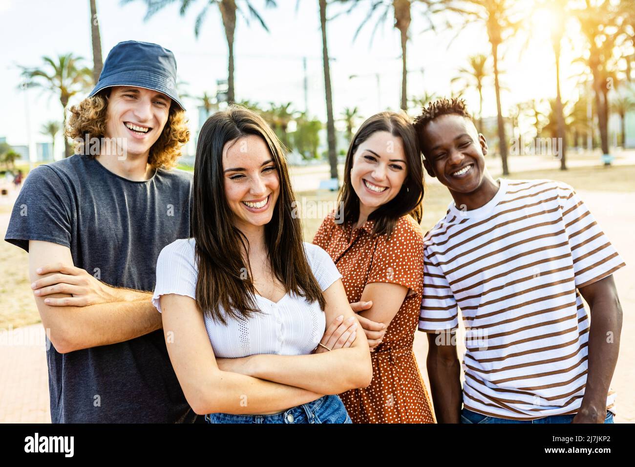 Groupe d'amis multiraciaux heureux posant à l'extérieur Banque D'Images