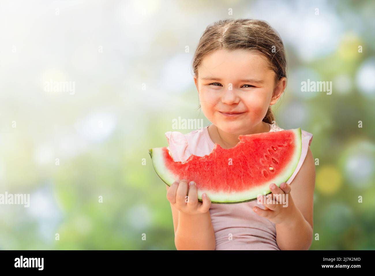 Fille heureuse avec morsure de pastèque isolée sur fond blanc Banque D'Images