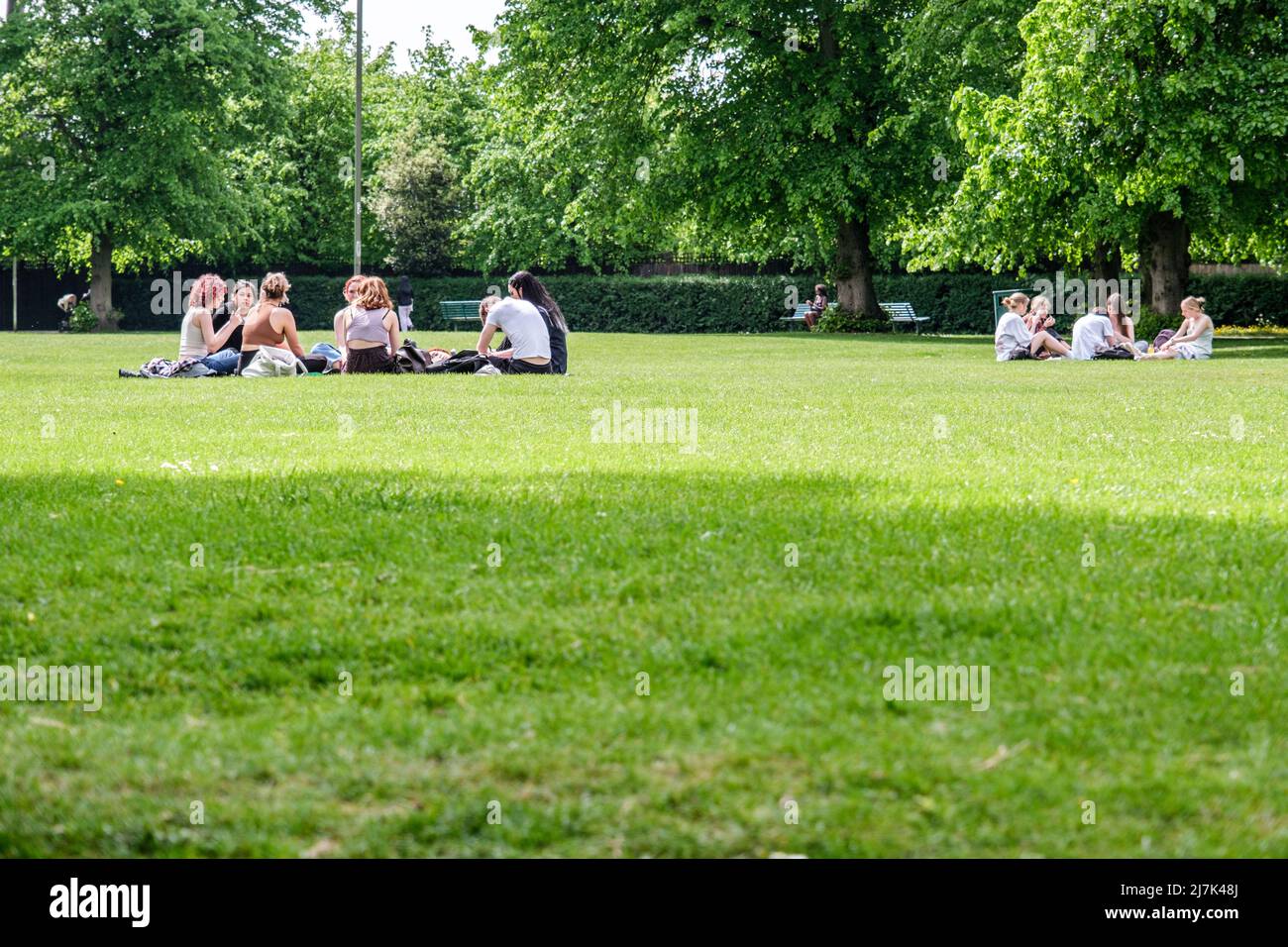 Epsom Surrey, Londres, le 09 2022 mai, des groupes de jeunes assis sur l'herbe dans Un parc relaxant et parlant Banque D'Images
