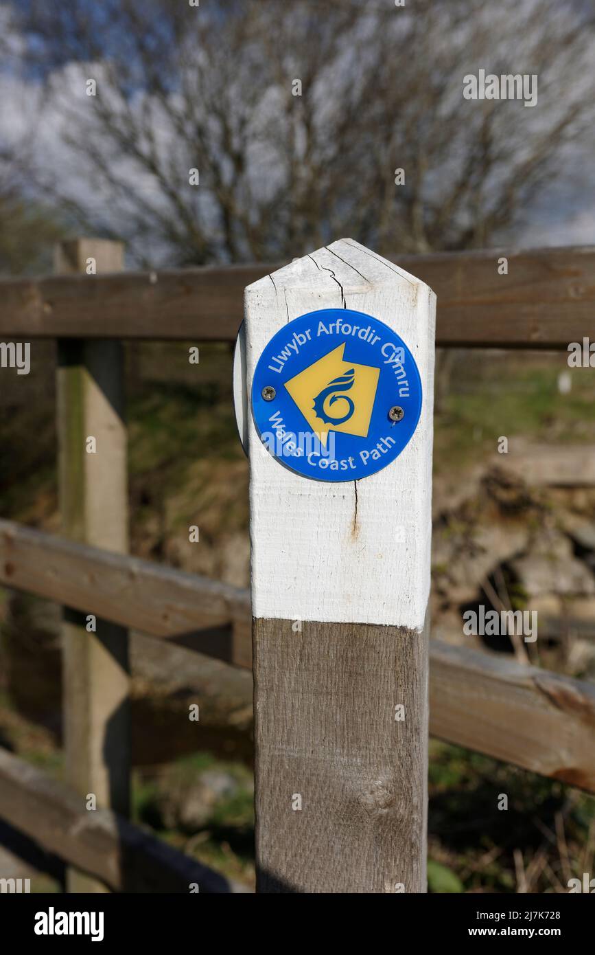 Panneau de signalisation de chemin de la côte gallois et anglais du pays de galles en bois bilingue, droit de passage public, avec clôture en bois en arrière-plan dans la campagne du nord du pays de galles au royaume-uni Banque D'Images